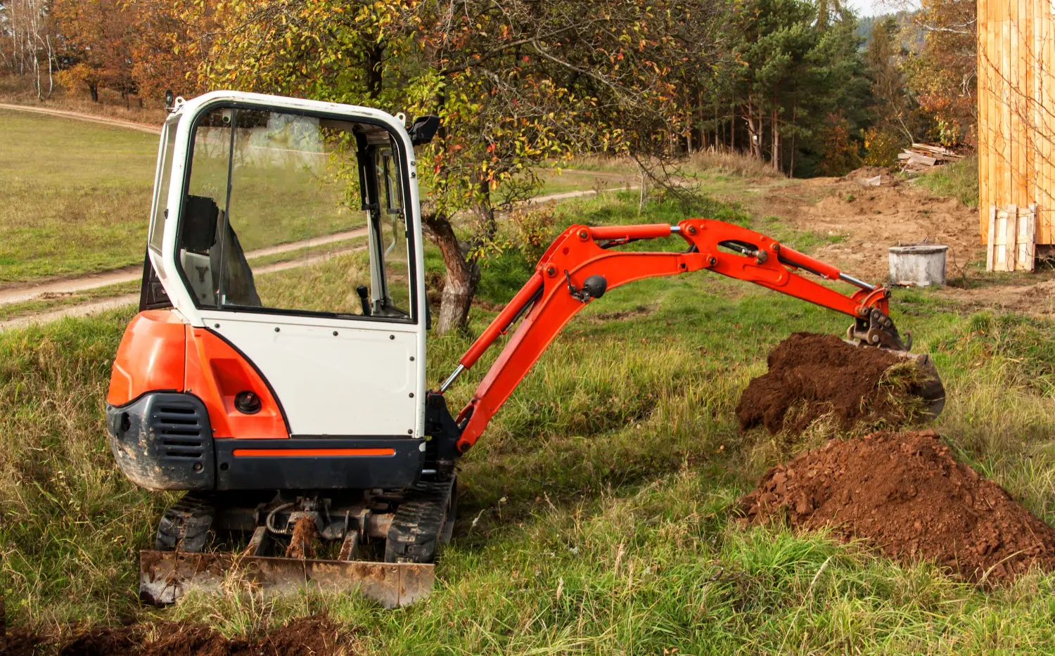 Minibagger auf einer Baustelle. Aushubarbeiten. Der Bagger arbeitet im Garten.
