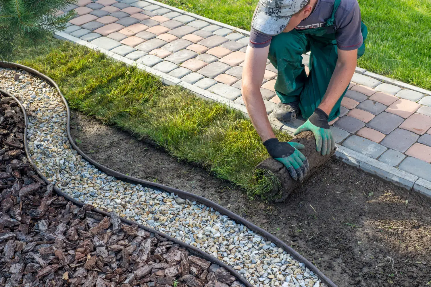  Landschaftsgärtner beim Verlegen von Rollrasen für neuen Rasen 